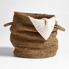 a large woven basket with a white bow on the top and bottom, sitting in front of a white background