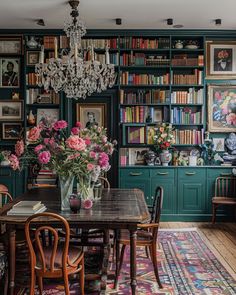 the dining room is decorated with bookshelves and floral arrangements