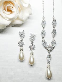 Please note I am currently on a short break, all orders placed will be shipped on Monday 28th October 2024.  The 'Zoe' Silver necklace set includes necklace &  earrings featuring Marquise and Round Simulated Crystals with a beautiful pearl drop.  A classic look for your wedding day. DETAILS Earring Length - 3.5cm Necklace Length - 50cm This set comes beautifully packaged in our Custom gift box. If you have any questions regarding this item, please don't hesitate to contact me. Thanks for stoppin Elegant Teardrop Bridal Necklace With Matching Earrings, Classic Teardrop Necklaces With Matching Earrings, Classic Wedding Jewelry Sets With Matching Earrings, Classic Wedding Necklace With Matching Earrings, Elegant Dangle Jewelry Sets For Wedding, Elegant Drop Necklace With Matching Earrings, Elegant Drop Necklaces With Matching Earrings, Wedding Jewelry Sets With Drop Matching Earrings, Wedding Jewelry Set With Drop Earrings