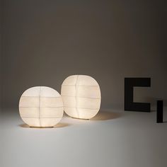 two lamps sitting next to each other in front of a black letter that says f