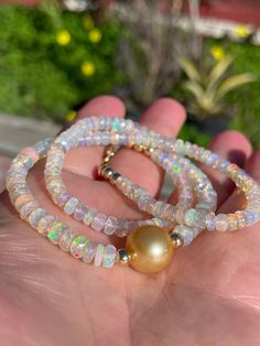 "Large (4.5-5mm) and beautiful faceted Ethiopian opal rondelles frame a flawless 11mm deep golden South Sea pearl.  The snow-white opals make a lovely contrast to the pearl, with their subtle multi-colored fire, and the South Sea pearl is a rich shade of gold. Necklace measures 16\" - 19\" in length and can be worn as a choker and layered with other pieces; it comes accented with 14K yellow gold-filled beads around the pearl and at the lobster clasp, with an additional 3\" gold-filled extender chain at the clasp.  If you prefer a different length, please convo me or let me know in the check-out comments. Thanks for checking out my shop!" Gold Opal Round Beads Necklace, Gold Opal Necklace With Round Beads, Gold Opal Single Strand Jewelry, Gold Opal Jewelry With Round Beads, Elegant White Pink Opal Jewelry, Faceted Round Opal Jewelry, Round Faceted Opal Jewelry, White Pink Opal Gemstone Jewelry, White Beaded Opal Jewelry