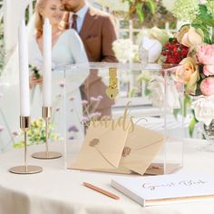 a couple standing next to each other in front of a table with cards and candles