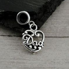 "This Dad Heart Charm comes with a silver dangle bead as pictured.   Fits on all major brand European style bracelets. A list of compatible chains is available here: https://etsy.me/2BY7DAW { DETAILS } ★ Charm Metal: 925 Sterling Silver ★ Bead Metal: Stainless Steel ★ Finish Color: Silver ★ Charm Size: 3/8\" x 5/8\" ★ Style: One-sided ★ Attachment: 5mm diameter large hole bead ★ Available without bead attached upon request Photo is not to scale and may appear larger to show detail. Refer to exac Silver Sterling Silver Charm Bracelet For Mother's Day, Silver Sterling Mother's Day Charm Bracelet, Mother's Day Silver Sterling Charm Bracelet, Silver Dangling Charms For Mother's Day, Mother's Day Silver Dangling Charms, Silver Charms For Jewelry Making On Mother's Day, Father's Day Silver Charms Jewelry, Sterling Silver Charm Bracelet For Mother's Day, Silver Heart Beads Dangle Jewelry