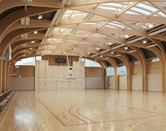 an indoor basketball court with wooden floors and walls