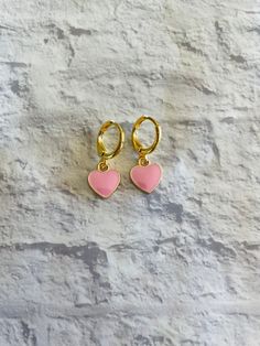 These cute and dainty gold-plated huggie earrings feature mini pink heart charms! Pink Drop Huggie Earrings, Cute Pink Hoop Earrings For Valentine's Day, Pink Hoop Earrings For Valentine's Day, Pink Heart Huggie Earrings For Pierced Ears, Pink Huggie Heart Earrings For Valentine's Day, Pink Huggie Heart Earrings For Pierced Ears, Pink Heart Huggie Earrings For Valentine's Day, Trendy Small Hoop Heart Earrings As Gift, Cute Pink Huggie Jewelry