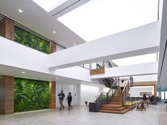 people are standing in the lobby of an office building with green walls on the wall