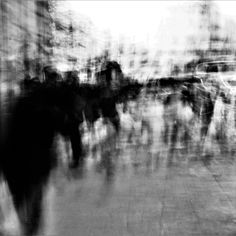 black and white photograph of people walking down the street