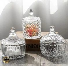 three glass jars sitting on top of a wooden table