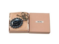 a pink box with a black and white beaded keychain in it's packaging