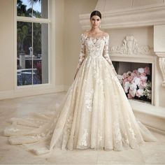 a woman in a wedding dress standing next to a fireplace