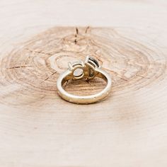 two wedding rings sitting on top of a piece of wood that has been cut in half