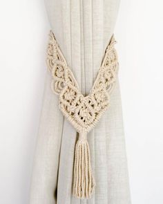 a white curtain with a tassel hanging from it's side