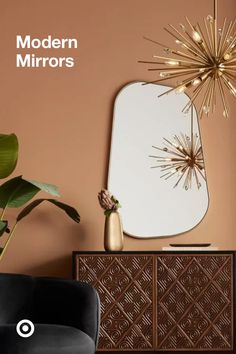 a modern mirror on the wall next to a black chair with a plant in it