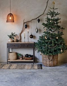 a small christmas tree sitting next to a wooden table with ornaments on top of it