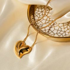 Our Embrace Heart Pendant Necklace is a symbol of enduring love, plated in sumptuous 18k gold for an everlasting shine. Its waterproof stainless steel composition ensures it is as resilient as it is beautiful. Designed to stand out, the heart pendant is a graceful twist on a classic shape, making it the perfect centerpiece for any outfit. And for those who adore a complete look, this necklace pairs seamlessly with our matching Embrace Heart Earrings, each reflecting the light and love you carry within. Heart Shaped Pendant Necklace, Rhinestone Statement Necklace, Golden Jewelry, Gold Heart Necklace, Waterproof Jewelry, Feather Necklaces, Heart Shape Pendant, Faux Pearl Necklace, Turquoise Pendant