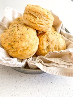 three biscuits sitting in a basket on top of a table