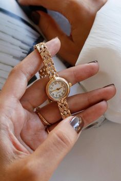 Discover timeless elegance with our stunning vintage gold watch, designed for the modern woman who appreciates classic beauty. With a case diameter of 20-25 mm, this small watch is the perfect size to make a stylish statement without overwhelming your wrist. Crafted from durable metal, both in the case material and the band material, this womens gold watch combines durability with sophistication. Its thick gold watch design exudes luxury, while the dainty watch aesthetic ensures it remains delicate and refined. This exquisite vintage watch is more than just a timepiece; it's a celebration of vintage charm. Whether you're adding to your collection or searching for the perfect accessory to elevate your outfit, this vintage womens watch is a fantastic choice. Ideal for any occasion, this gold Classic Gold Watch Women, Vintage Gold Stainless Steel Watch, Elegant Gold Stainless Steel Watch Accessories, Everyday Gold Watch With Metal Dial, Elegant Metal Watch With Round Dial, Elegant Rose Gold Metal Watch Accessories, Elegant Gold Stainless Steel Watch, Gold Minimalist Watch With Metal Dial, Gold Minimalist Watch Accessories For Formal Occasions