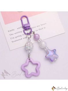 a purple key chain with a star charm on it's end and a bead in the middle