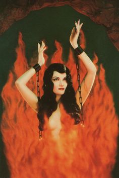 a woman is chained to chains in front of a large fire with her hands up