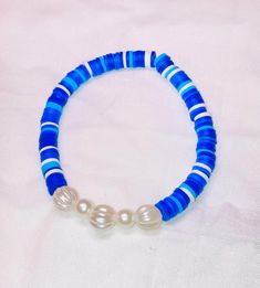 Cute blue and white beaded bracelet. These are high quality handmade bracelets. They are made with an elastic string so will fit lots of sizes. They are around 6.75 inches. Please note that each braclet will have a very similar beading pattern but not exactly identical. Blue Heishi Beads Stretch Bracelet With Colorful Beads, Blue Bracelets With Large Beads For Beach, Blue Beaded Bracelets With 8mm Beads For Beach, Blue Beach Bracelets With Large Beads, Casual Blue Heishi Beads Stretch Bracelet, Casual Blue Pearl Bracelet With Round Beads, Blue Pearl Bracelet With Spacer Beads, Blue Heishi Beads Stretch Bracelet Gift, Blue Stretch Bracelet With Colorful Heishi Beads