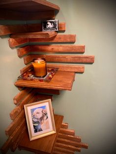 a candle is sitting on a shelf next to a framed photo and some wood planks