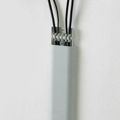 three wires are attached to the side of a white wall mounted electrical device with black cords