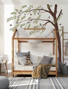 a child's bedroom with a canopy bed and tree wall decal on the wall