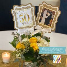 a vase filled with yellow flowers next to two cards on top of a table covered in gold sequins