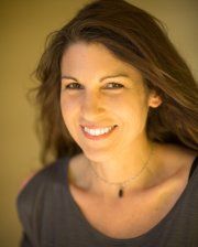 a woman with long hair smiling at the camera