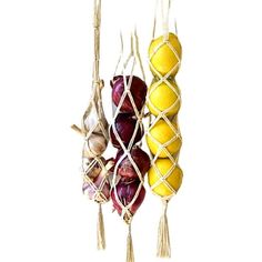 three balls are hanging from a string with tassels attached to the strings, and one is yellow