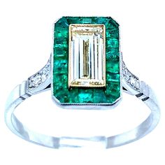 Platinum ring with one baguette cut diamond that weighs 0.71 carat, 6 old mine cut diamonds that weigh 0.09 carat, and 22 emeralds that weigh 0.55 carat. An art deco recreation, this ring weighs 3.6 grams. Size 7.25. Diamond Emerald Ring, Baguette Cut Diamond, Platinum Ring, Baguette Cut, Emerald Ring, Solitaire Ring, Mirror Table, Diamond Cuts, Platinum