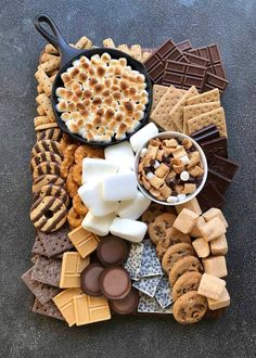 a platter filled with crackers, marshmallows, and other snacks