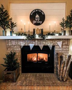 a fireplace decorated for christmas with lit candles