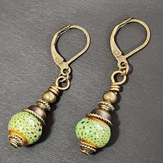 "If you love vintage things, and rustic/retro style, you will love adding these earrings to your collection. Hand crafted with handmade ceramic clay beads in speckled green round beads. Accent beads are metal. These earrings are so cute! Ceramic beads are about 9mm These earrings are about 1.5 inches long including the ear wires.  The metal is antiqued bronze colored. The earwires are alloy (nickel-free, lead-free, cadmium-free) which is good for most people with sensitive ears. Ear wires are le Vintage Single Earring For Everyday Wear, Vintage Single Earring For Everyday, Vintage Everyday Earrings With Ear Wire, Vintage Brass Beaded Drop Earrings, Retro Handmade Drop Earrings, Vintage Nickel-free Earrings For Everyday, Everyday Vintage Round Earrings, Handmade Retro Dangle Earrings, Nickel-free Vintage Drop Beaded Earrings