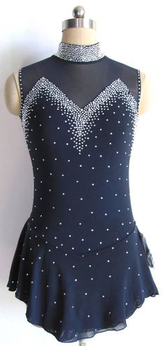 a dress on a mannequin is shown in front of a white wall and it has silver beading