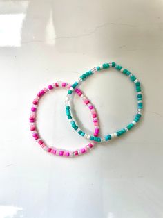 These bracelets are made out of stretchy string and seed beads. It's so cute and will match almost anything! All orders will recieve 2 stickers and a ring for free. Summer White Hand-strung Friendship Bracelets, Trendy Pink Heishi Beads, Hand-strung Turquoise Beaded Bracelets For Summer, Beach Season Tiny Beads Bracelets, Tiny Beads Bracelets For Beach Season Gift, Tiny Beads Bracelets For Summer Beach, Green Heishi Beads Bracelets For Summer, Turquoise Friendship Bracelets With Tiny Beads For Summer, Summer Gift Heishi Beads Friendship Bracelets