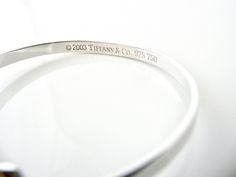 Overview: Offered for sale is a wonderful and gorgeous Tiffany & Co. Sterling Silver 18K Gold Heart Hook Bangle. Definitely a Tiffany piece that you will get your money's value for. It works perfectly with pretty much any attire your put on, AND is a great statement piece. The piece looks fabulous worn alone, but is also a wonderful piece with which to start or add to your Tiffany collection. Very versatile indeed! This piece is simple, elegant, and classic all rolled into one bracelet. Imag Luxury Sterling Silver Heart Bracelet For Anniversary, Luxury Sterling Silver Bracelets For Valentine's Day, Adjustable Bracelets With Shiny Finish For Wedding, Classic Hallmarked Cuff Bracelet For Wedding, Luxury Hallmarked White Gold Cuff Bracelet, Classic Jewelry Bracelet For Valentine's Day, Luxury White Gold Heart Bracelet For Wedding, Classic Bracelets For Anniversary On Valentine's Day, Luxury Engraved Cuff Bracelet For Anniversary