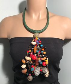 "Immerse yourself in the rich tapestry of African culture with our handmade necklace. Crafted with meticulous detail, this piece showcases traditional craftsmanship, vibrant colors, and intricate beadwork. Each bead tells a story, making this necklace not just an accessory but a cultural statement. Embrace the spirit of Africa and adorn yourself with a unique piece that reflects heritage and style. Perfect for those who appreciate the artistry and diversity of African jewelry." Material: Glass b Bohemian Beads For Jewelry Making And Festivals, Bohemian Beaded Necklaces With Colorful Beads For Crafting, Handmade Green Bohemian Beaded Necklaces, Handmade Green Beaded Necklaces For Festivals, Bohemian Bib Necklaces With Large Round Beads, Bohemian Bib Necklace With Round Beads, Bohemian Bib Necklace With Beaded Chain, Bohemian Bib Necklace With Round Beaded Chain, Handmade Adjustable Bohemian Bib Necklaces