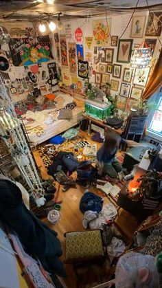 a messy room with lots of clutter on the floor and pictures all over the walls