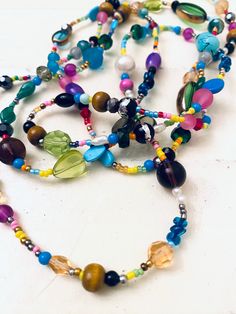 "This is a fun, super colorful, boho style beaded necklace. I made it with an assortment of stone, glass, plastic and metal bead, seed beads, pearls and more! Wear it long or wrap it! Length: 54\"; has no clasp.    Thank you so very much for visiting my shop!!  Click here for more: http://www.etsy.com/shop/jHenSunshine  New to my shop? See my policies section for any additional questions." Colorful Faceted Beads Jewelry For Festivals, Multicolor Beaded Bohemian Crystal Necklaces, Bohemian Multicolor Beaded Crystal Necklaces, Colorful Bohemian Faceted Beads, Bohemian Faceted Beads For Festival, Hippie Tiny Beads For Festival, Summer Multi-strand Colorful Beaded Necklaces, Spiritual Multi-strand Beaded Long Necklace, Adjustable Multicolor Beaded Necklaces For Festivals