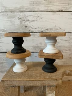 two black and white candlesticks sitting on top of a wooden table