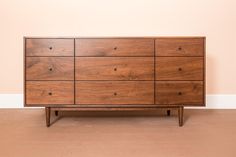 a large wooden dresser sitting on top of a hard wood floor next to a wall