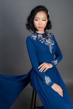 Beautiful custom-made ao dai in dark blue silk. Spectacular, machine embroidered floral design. Price includes dress and pants. After your purchase is complete, we will email you a link to a simple online form to enter your measurements - we will then create the most flattering custom fit for your individual body type. Shipping details Please allow up 4 weeks for custom making and shipping, once measurements are received. Please note; we make every effort to ensure our photos accurately represen Traditional Drape Evening Dresses For Spring, Spring Evening Dress With Traditional Drape, Festive Blue Dress With Embroidered Sleeves, Blue Wedding Dresses With Embroidered Sleeves, Elegant Dress With Embroidered Sleeves And Traditional Drape, Fitted Blue Gown With Floral Embroidery, Blue Dress With Resham Embroidery For Evening, Blue Evening Dress With Resham Embroidery, Elegant Embroidered Ao Dai For Evening