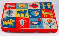 a red and blue pillow with animals on it