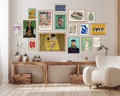 a white chair sitting in front of a wooden table next to a wall with pictures on it