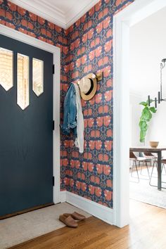 a hat is hanging on the wall next to a blue door with an orange and white pattern