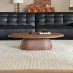 a living room with a black leather couch and coffee table in front of the couch