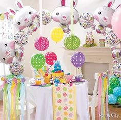 a table topped with lots of balloons and bunnies