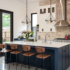 a kitchen island with four chairs next to it and an oven in the back ground