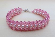 "The elegant color of pink combine with an accent of AB rose pink makes the bracelet a sweet delicate with a little bit of dazzle for your wrist. This bracelet is hand stitch using colored Czech glass pearls, swarovski bicone crystal and embellished the edge with Japanese seed beads to make a chain. The bead work is done in flat spiral style. I use the fireline beading thread to stitch and silver tone magnetic clasp to finished it off and for an easy wear. The bracelet measures 7 1/4\" and will Elegant Adjustable Pink Bracelet, Adjustable Pink Pearl Bracelet Feminine Style, Pink Adjustable Feminine Pearl Bracelet, Adjustable Feminine Pink Pearl Bracelet, Pink Jubilee Bracelet With Round Beads, Handmade Pink Crystal Elegant Bracelet, Pink Beaded Pearl Bracelet For Wedding, Handmade Elegant Pink Crystal Bracelet, Handmade Pink Crystal Bracelet For Wedding